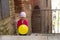 Cute little girl dressed in red playing with yellow balloon on t