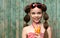 Cute little girl drinks lemonade front of old rural wooden background. Kid holds glass with summer beverage cold tea