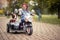 Cute little girl  driving electrical motorcycle toy with sidecar and her dog in it