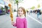 Cute little girl eating fried potato on a stick