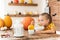 Cute little girl eating pumpkin soup in Halloween decorated dinning room. Autumn season comfort food.