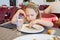 Cute little girl eating a sardine cooked in a white dish in restaurant