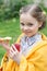 Cute little girl eating snack and drinking juice