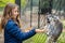 cute little girl feeding adorable lemur catta in a zoo