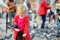 Cute little girl feeding and chasing birds on Dam Square in Amsterdam on summer day