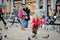 Cute little girl feeding and chasing birds on Dam Square in Amsterdam on summer day