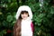 Cute little girl in fur coat under rowan tree