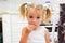 Cute little girl getting caught eating a cookie in the kitchen