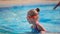 Cute little girl in goggles swimming in the swimming pool