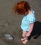 Cute little girl has found old fish in the beach