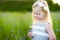 Cute little girl having fun a blooming cornflower field