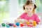 Cute little girl having fun with colorful modeling clay at a daycare