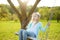 Cute little girl having fun on a swing outdoors in summer garden. Summer leisure for kids