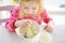 Cute little girl having oatmeal for breakfast