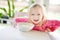 Cute little girl having oatmeal for breakfast