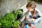 Cute little girl helping in a garden. Child taking part in outdoor household chores