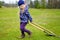 Cute little girl helping in a garden. Child taking part in outdoor household chores