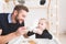 Cute little girl and her father drink tea with cookies at home.