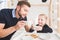 Cute little girl and her father drink tea with cookies at home.