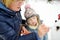 Cute little girl and her grandma building a snowman in the backyard. Cute child playing in a snow