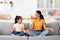 Cute Little Girl And Her Young Mother Meditating Together At Home