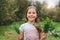 Cute little girl holding herbs outside