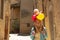 Cute little girl holding a yellow balloon on the shoulders of he