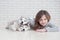 Cute little girl hugging husky puppy on a white background