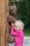 Cute little girl hugs wooden bear