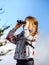 Cute little girl investigating Alps mountains using binocular. T