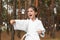 Cute little girl in kimono practicing karate in forest