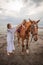 Cute little girl lays down on the withers of the horse. Mom and daughter spending time together. Mother`s day. Copy space. Sunset