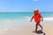 Cute little girl in life jacket on summer beach, safety