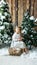 Cute little girl in a light dress sits on a stump among artificial fir trees and artificial snow with a wicker basket with toys.