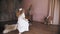 cute little girl. little Princess, in a snow-white lace dress, dances, whirls, barefoot in the room.