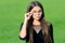 Cute little girl with long hair in fashion black wear fix corrective glasses with beauty look green grass sunny summer