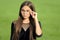 Cute little girl with long hair in fashion black wear fix corrective glasses with beauty look green grass sunny summer