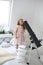 A cute little girl is looking at a telescope on an aluminum stargazing stand in a room