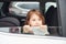 Cute little girl looks through window car. Conception of traveling and vaccation