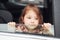 Cute little girl looks through window car. Conception of traveling and vaccation