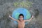 Cute little girl lying on a beautiful world painting with chalk labeled Planet on asphalt. Young volunteers do activities to save