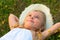 Cute little girl lying on the meadow and daydreami