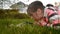 Cute little girl with a magnifying glass in the park looking at the grass