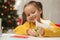 Cute little girl making paper angel for Saint Nicholas day