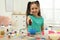 Cute little girl making slime toy at table