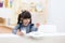 Cute little girl with milk mustache holding glass of milk