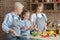 Cute little girl mixing salad under mom and granny supervision