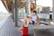 Cute little girl and mother on a railway station.