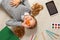 Cute little girl with O letter lying on the floor. The child is surrounded by a book, tablet, paints, brushes, pencils