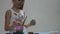 Cute little girl painter draws on the table and on himself on her clothes. slow motion